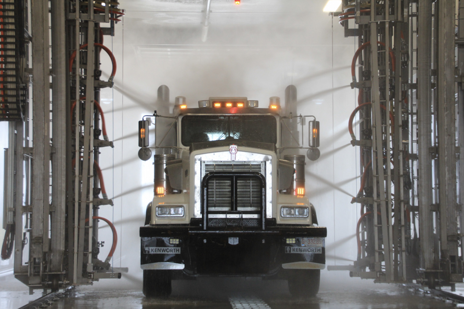 Tractor trailer being driven through a truck wash 