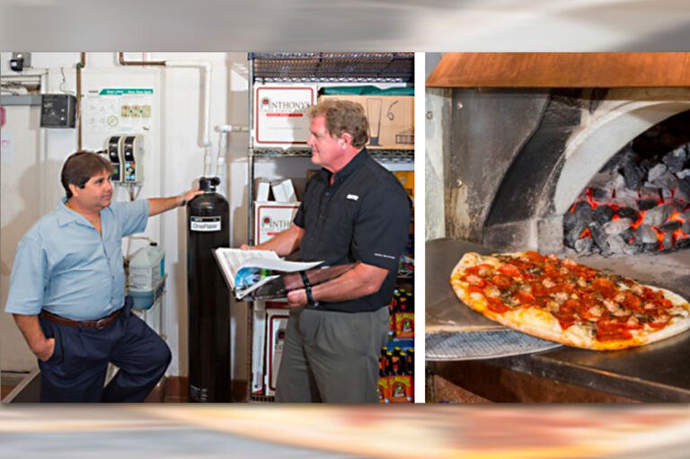 Two men installing a one flow system with a pizza oven to the right of them