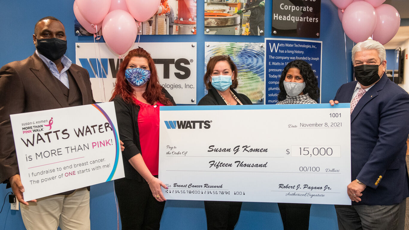 Susan G Komen showcases a $15,000 check that will be donated to breast cancer research on behalf of her and Watts Water Technologies. 