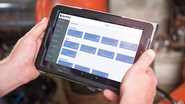 Person holding tablet with Synca dashboard showing