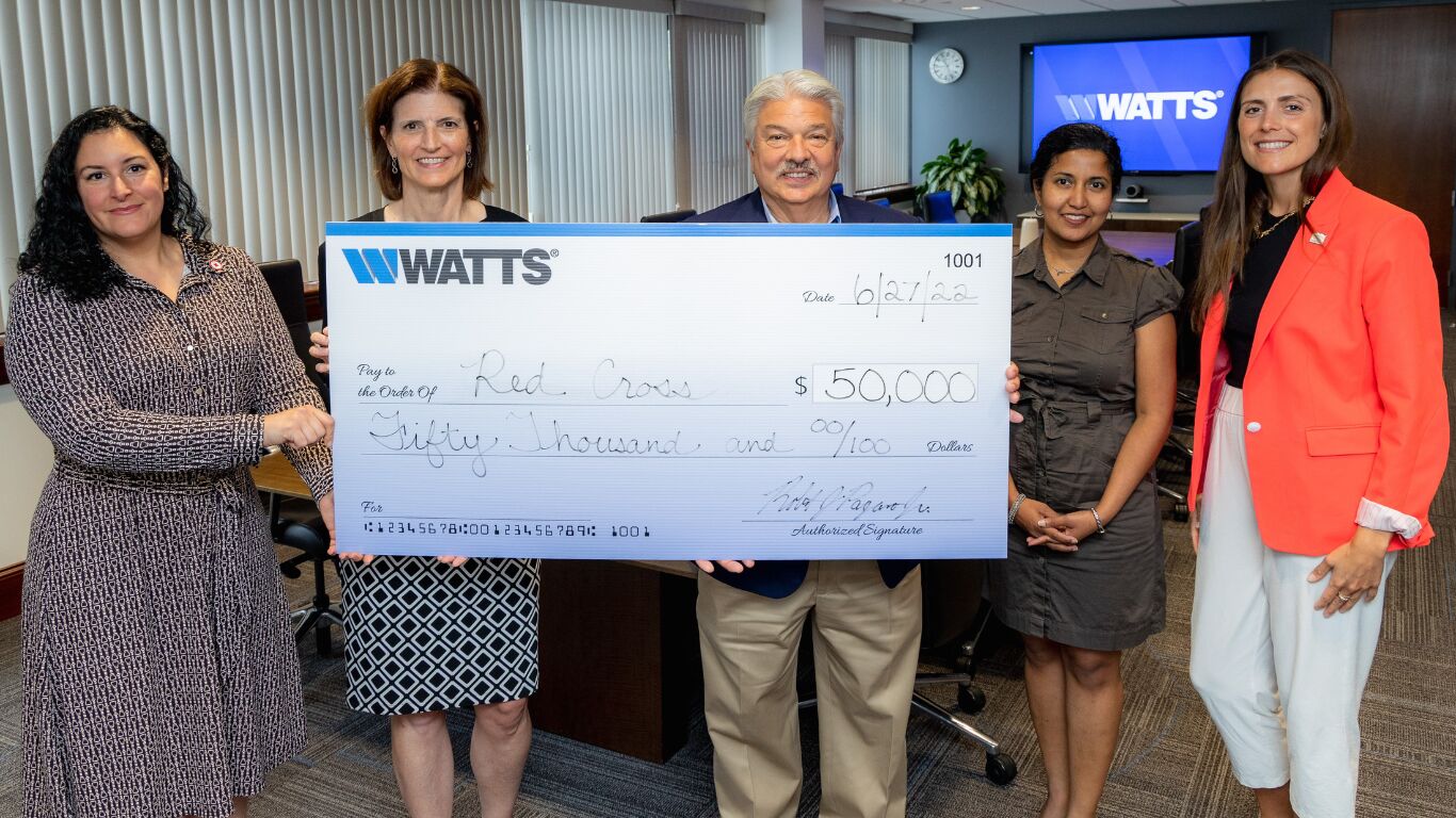 5 Watts Employees stand holding a $50,000 check made out to the Red Cross for Ukraine relief. 