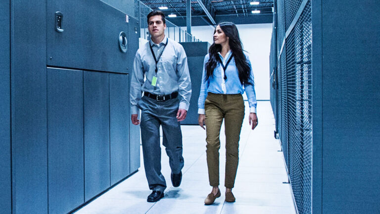 Two employees walking through server room